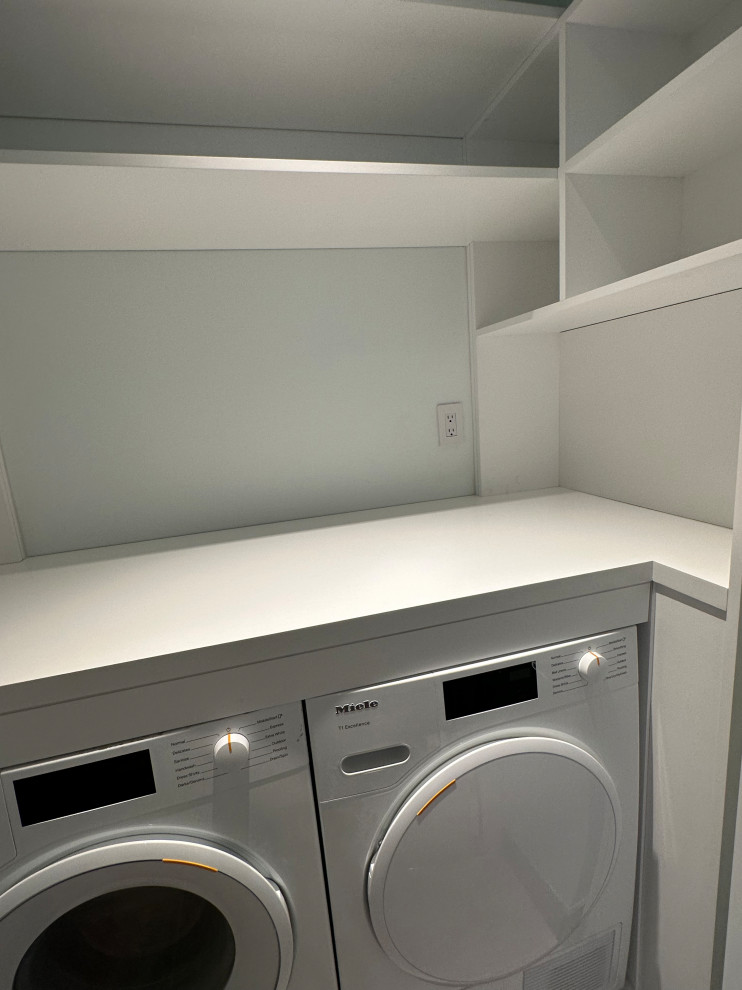 Inspiration for a small modern single-wall laundry cupboard in Other with open cabinets, white cabinets, wood worktops, white walls, slate flooring, a side by side washer and dryer, grey floors and white worktops.