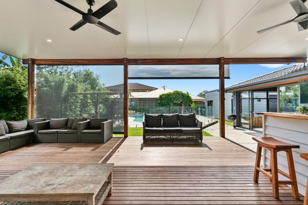 Mid-sized modern backyard deck in Brisbane with an outdoor kitchen and a roof extension.