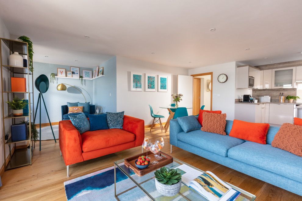 Mittelgroßes, Repräsentatives, Offenes Maritimes Wohnzimmer ohne Kamin mit weißer Wandfarbe, braunem Holzboden, Eck-TV, orangem Boden und Tapetenwänden in Cornwall