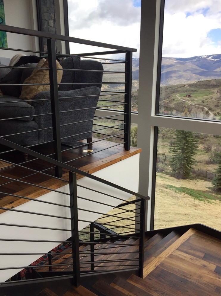 Expansive modern wood floating staircase in Denver with metal risers and metal railing.
