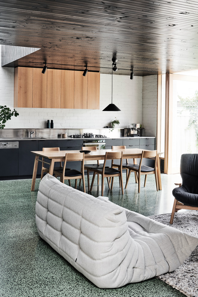 This is an example of a mid-sized modern open plan dining with white walls, concrete floors, no fireplace and green floor.