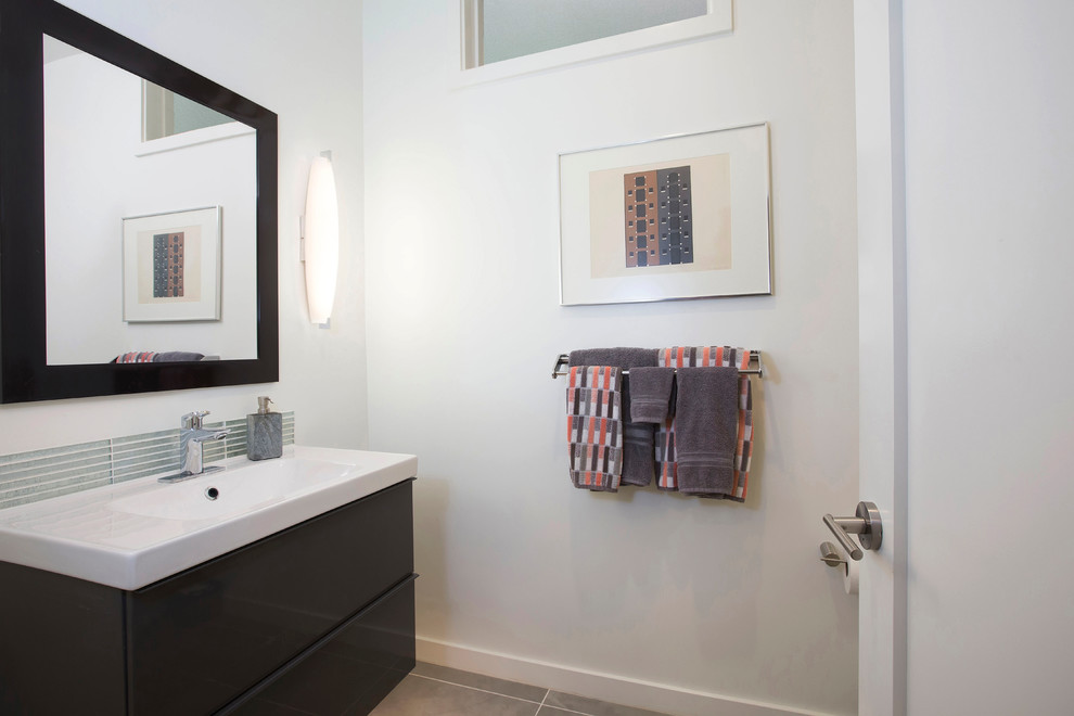 Mid-sized modern 3/4 bathroom in San Diego with flat-panel cabinets, dark wood cabinets, an open shower, a one-piece toilet, green tile, glass tile, grey walls, porcelain floors, an integrated sink and solid surface benchtops.