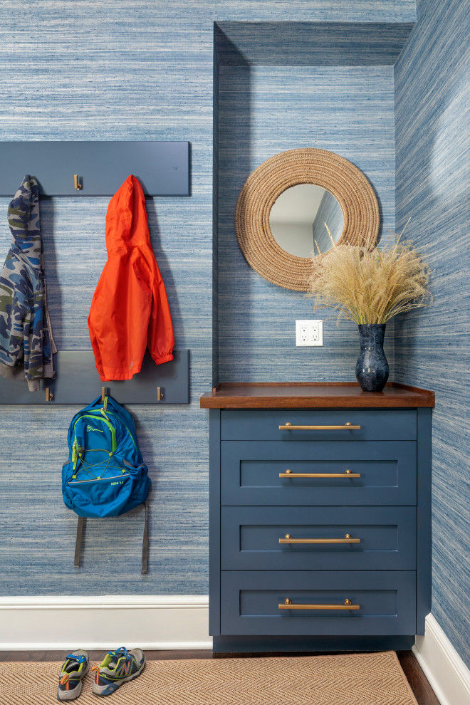 This is an example of a mid-sized country mudroom in New York with blue walls, dark hardwood floors, brown floor and wallpaper.