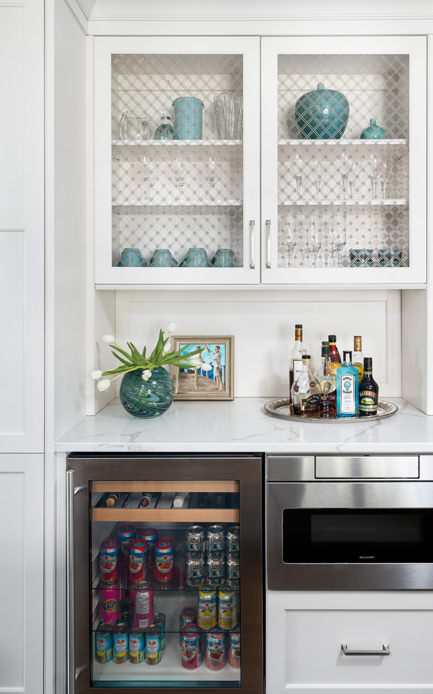 This is an example of a small transitional single-wall home bar in Chicago with no sink, white cabinets, white splashback, white benchtop and marble benchtops.