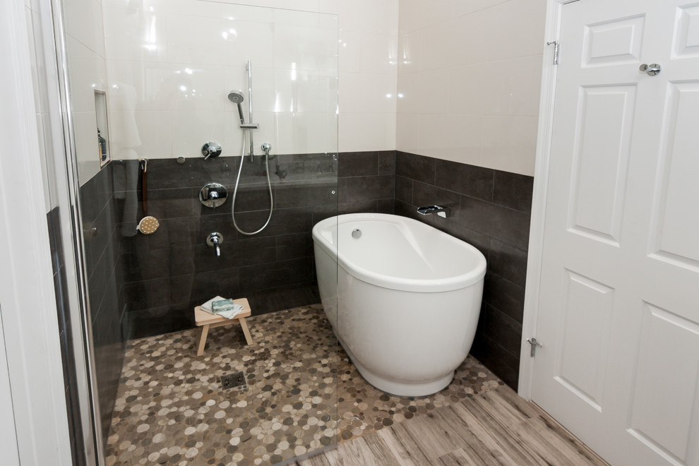 Photo of a mid-sized asian master wet room bathroom in DC Metro with shaker cabinets, grey cabinets, a freestanding tub, a two-piece toilet, beige tile, porcelain tile, beige walls, porcelain floors, an undermount sink, engineered quartz benchtops, beige floor and a hinged shower door.