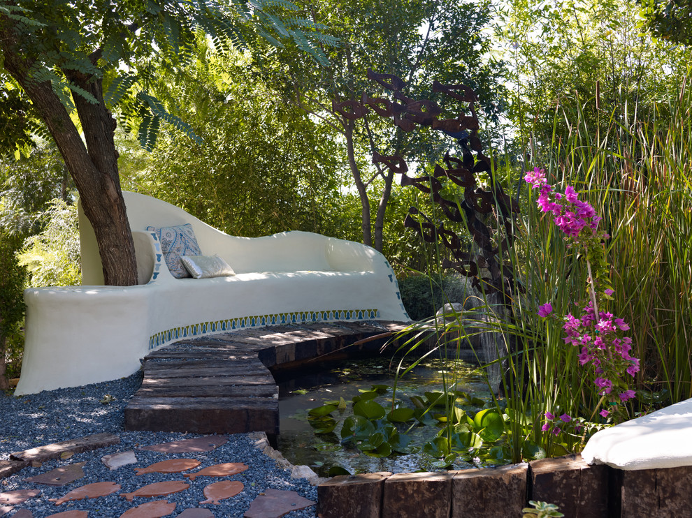 Photo of a mediterranean garden in Sussex with with pond and gravel.