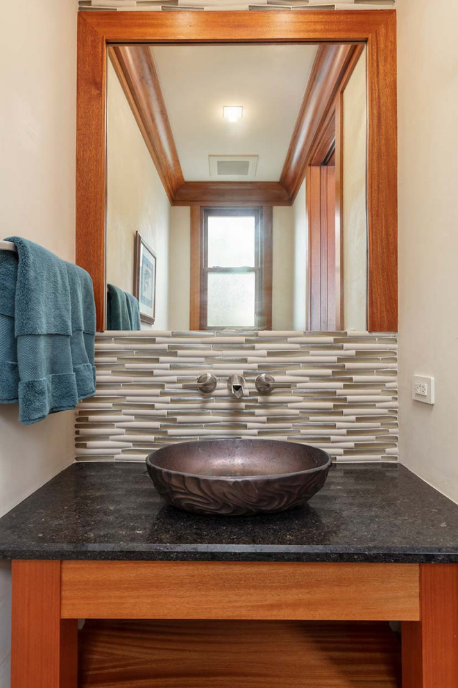 This is an example of a mid-sized tropical powder room in Minneapolis with a built-in vanity.