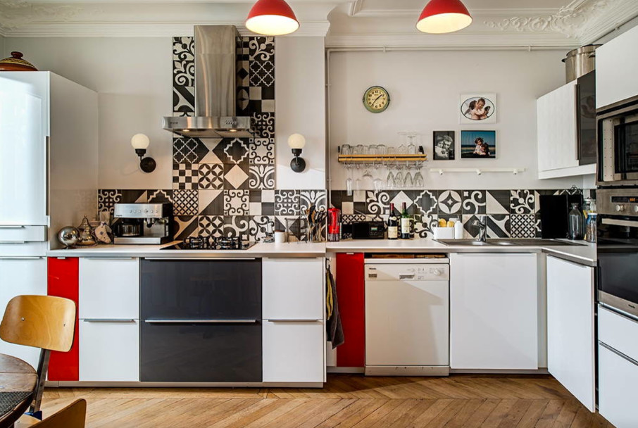 Photo of a large midcentury l-shaped open plan kitchen in Paris with a double-bowl sink, beaded inset cabinets, white cabinets, ceramic splashback, panelled appliances, light hardwood floors, laminate benchtops and multi-coloured splashback.