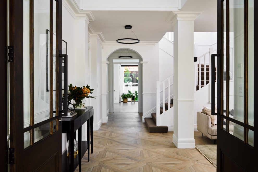 Design ideas for a large beach style foyer in Perth with white walls, porcelain floors, a double front door, a dark wood front door, beige floor and decorative wall panelling.