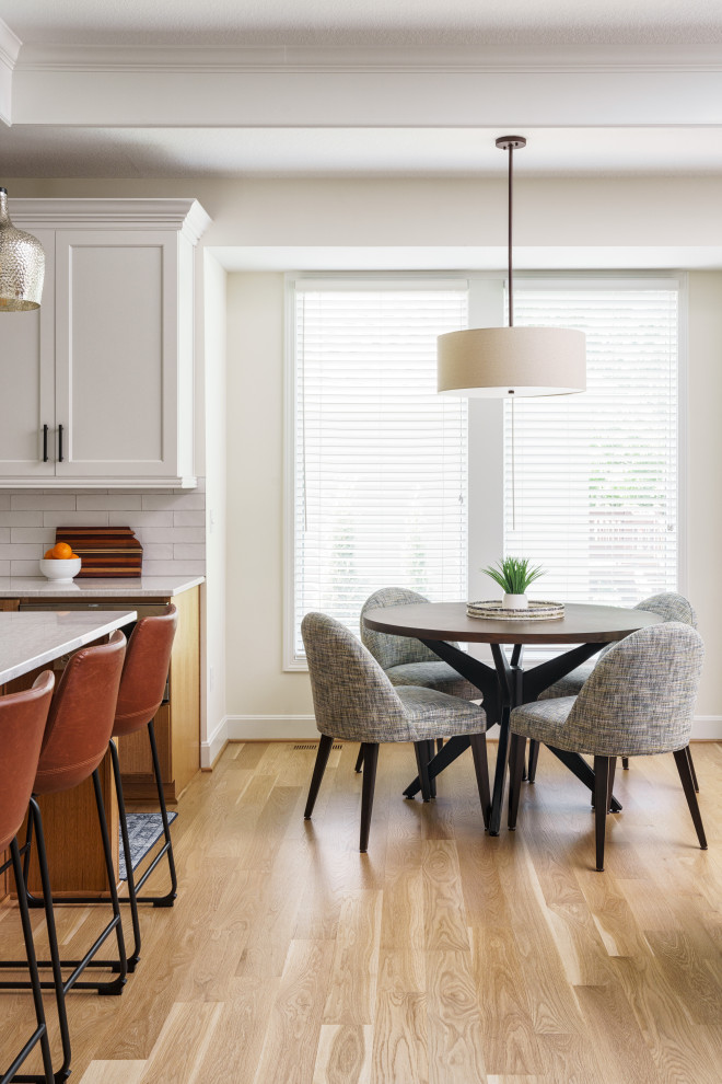 Photo of a mid-sized transitional dining room in Kansas City with white walls and light hardwood floors.