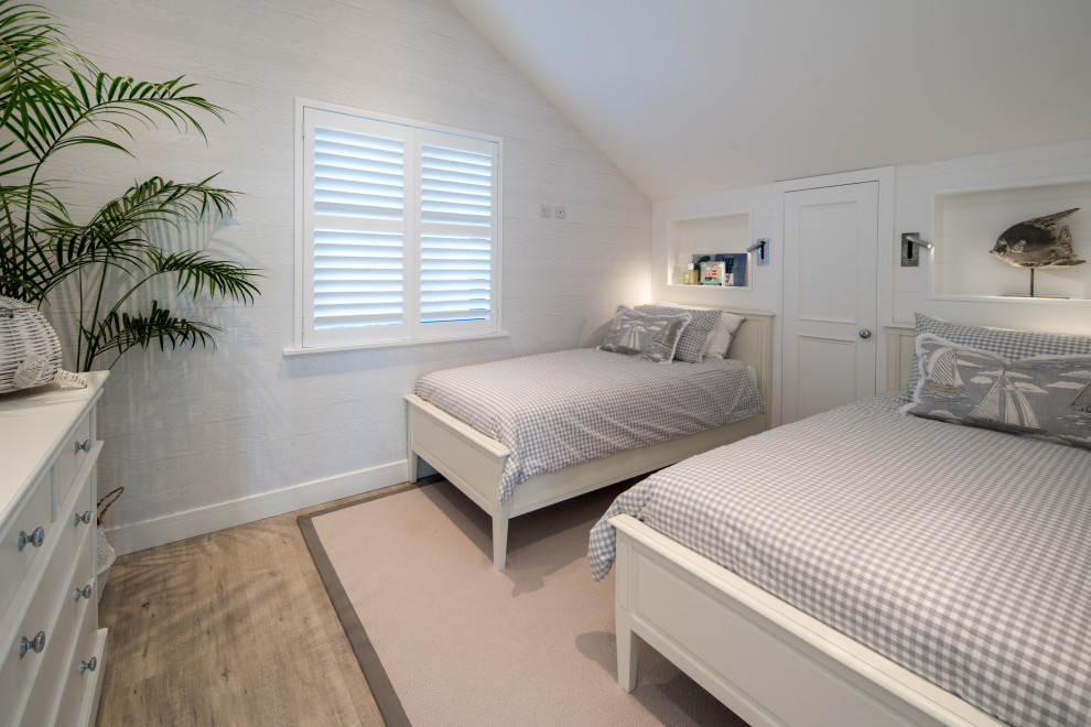 Exempel på ett mellanstort maritimt könsneutralt barnrum kombinerat med sovrum och för 4-10-åringar, med vita väggar, laminatgolv och grått golv