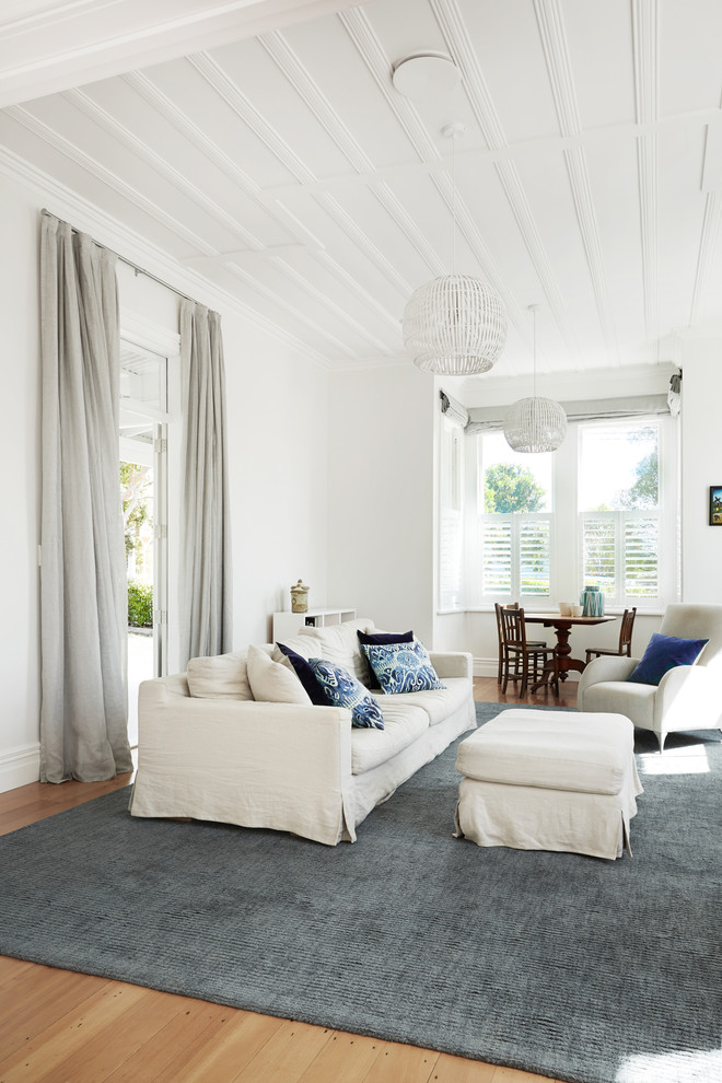 Photo of a transitional living room in Auckland with white walls.