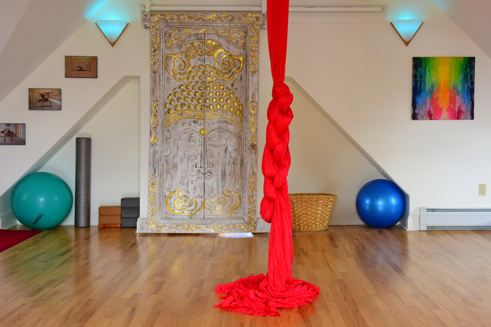 Large traditional home yoga studio in Boston with white walls and light hardwood floors.