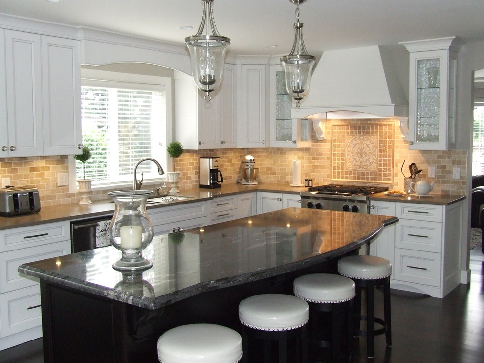 Mid-sized transitional l-shaped dark wood floor and brown floor eat-in kitchen photo in Vancouver with a double-bowl sink, recessed-panel cabinets, white cabinets, granite countertops, beige backsplash, travertine backsplash, stainless steel appliances and an island