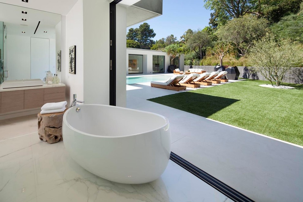 Inspiration for an expansive contemporary master bathroom in Los Angeles with flat-panel cabinets, light wood cabinets, a freestanding tub, an open shower, white walls, marble floors, a drop-in sink and marble benchtops.