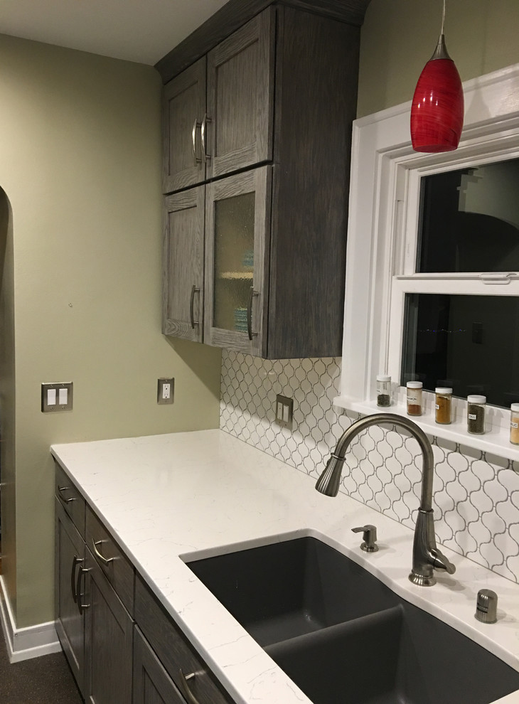 Enclosed kitchen - small transitional galley enclosed kitchen idea in Seattle with an undermount sink, shaker cabinets, gray cabinets, quartzite countertops, white backsplash, ceramic backsplash, stainless steel appliances and no island