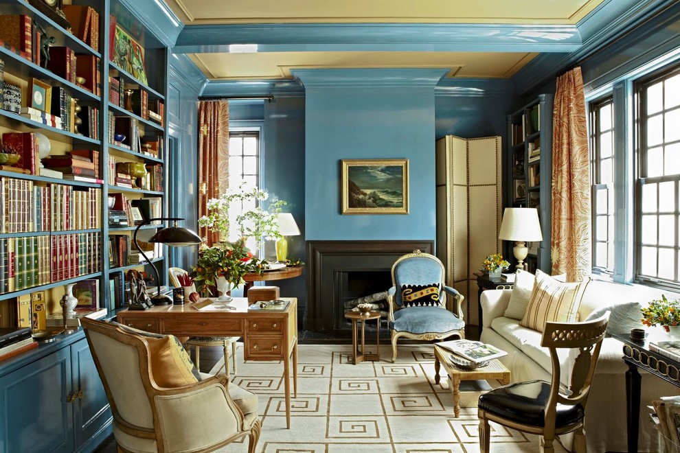 This is an example of a traditional study room in New York with blue walls, a standard fireplace and a freestanding desk.