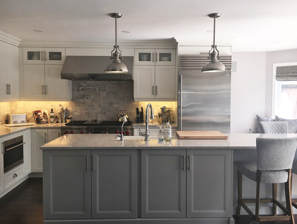 Transitional l-shaped brown floor eat-in kitchen photo with a farmhouse sink, white cabinets, quartz countertops, stainless steel appliances, an island and white countertops