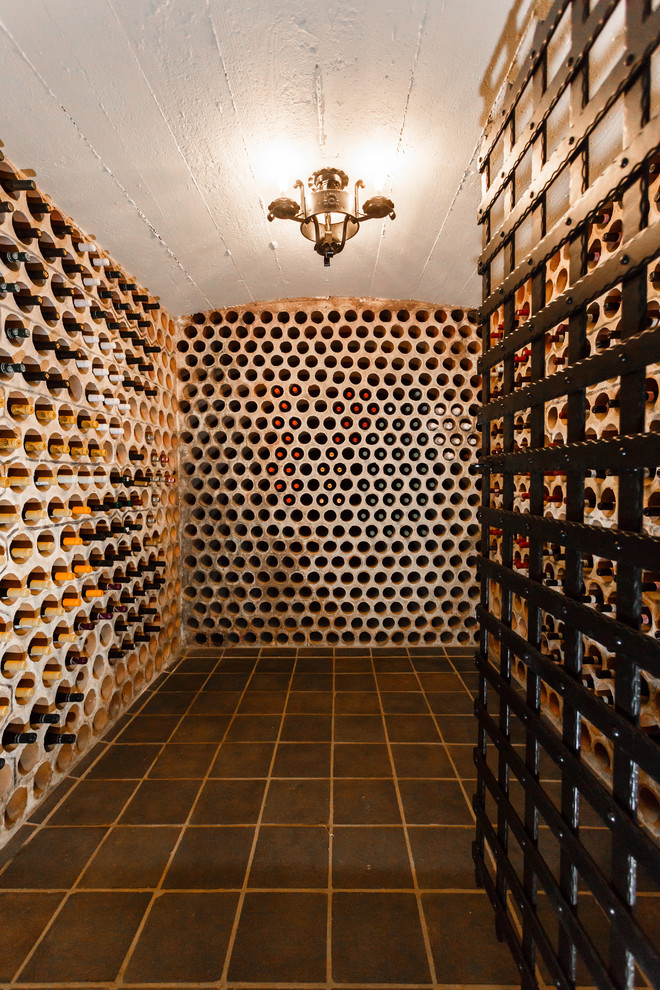 Photo of an expansive transitional wine cellar in New York with brick floors and display racks.