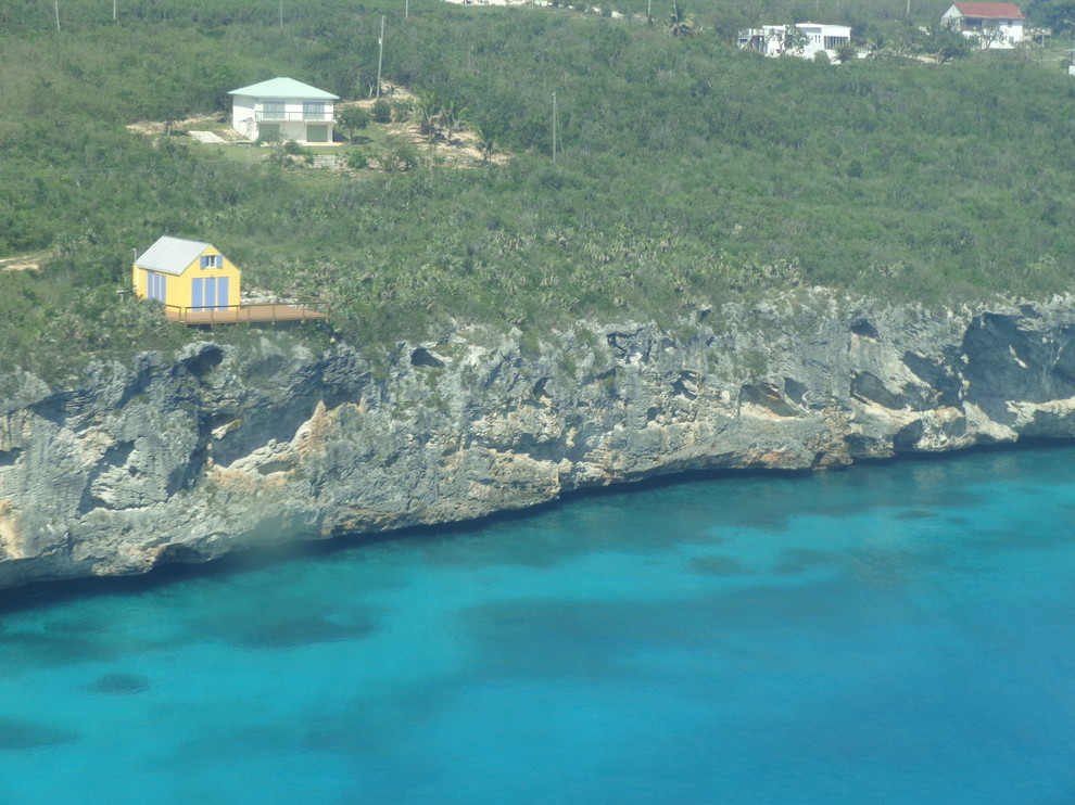 Small beach style yellow one-story mixed siding exterior home photo