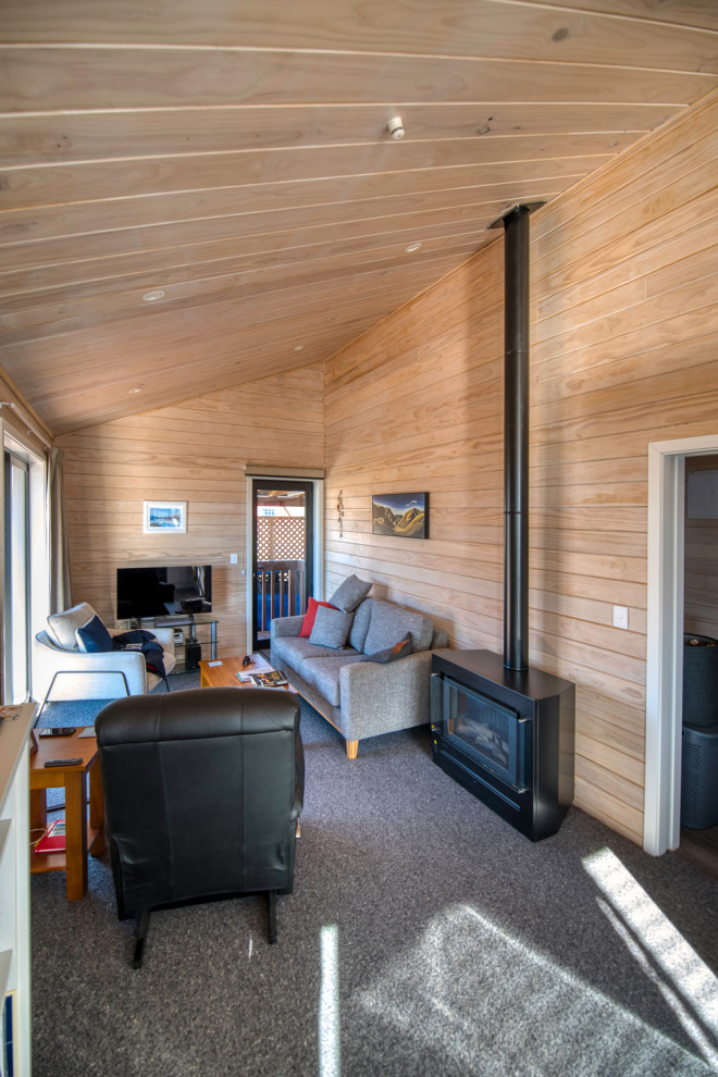 На фото: маленькая изолированная гостиная комната в стиле кантри с деревянными стенами для на участке и в саду