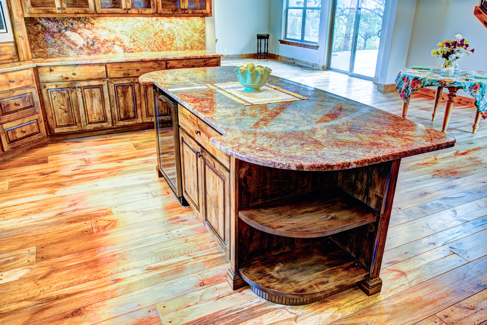 Example of a large mountain style u-shaped medium tone wood floor kitchen pantry design with a drop-in sink, glass-front cabinets, medium tone wood cabinets, beige backsplash, stainless steel appliances and an island