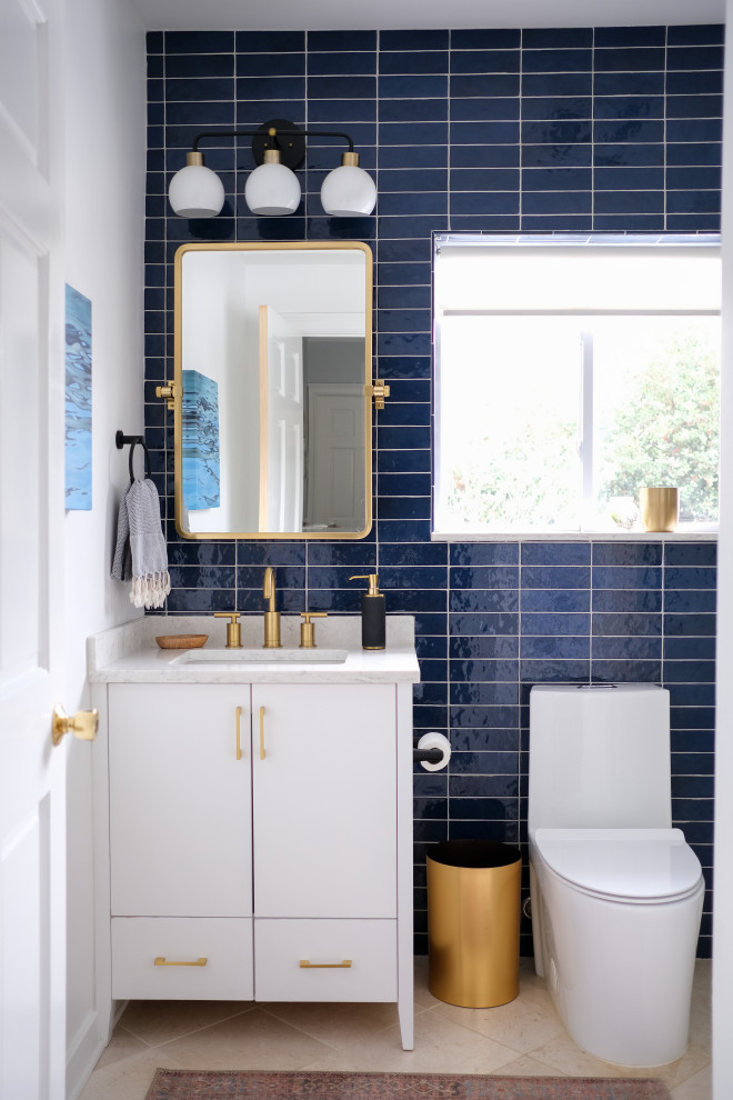 Design ideas for a small contemporary bathroom in New York with flat-panel cabinets, white cabinets, a corner shower, blue tiles, metro tiles, white walls, marble flooring, a submerged sink, engineered stone worktops, beige floors, a hinged door, grey worktops, a single sink and a freestanding vanity unit.