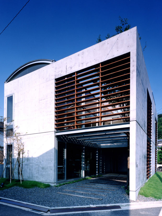 Idée de décoration pour une façade de maison grise minimaliste en béton de taille moyenne et à un étage avec un toit en métal et un toit gris.