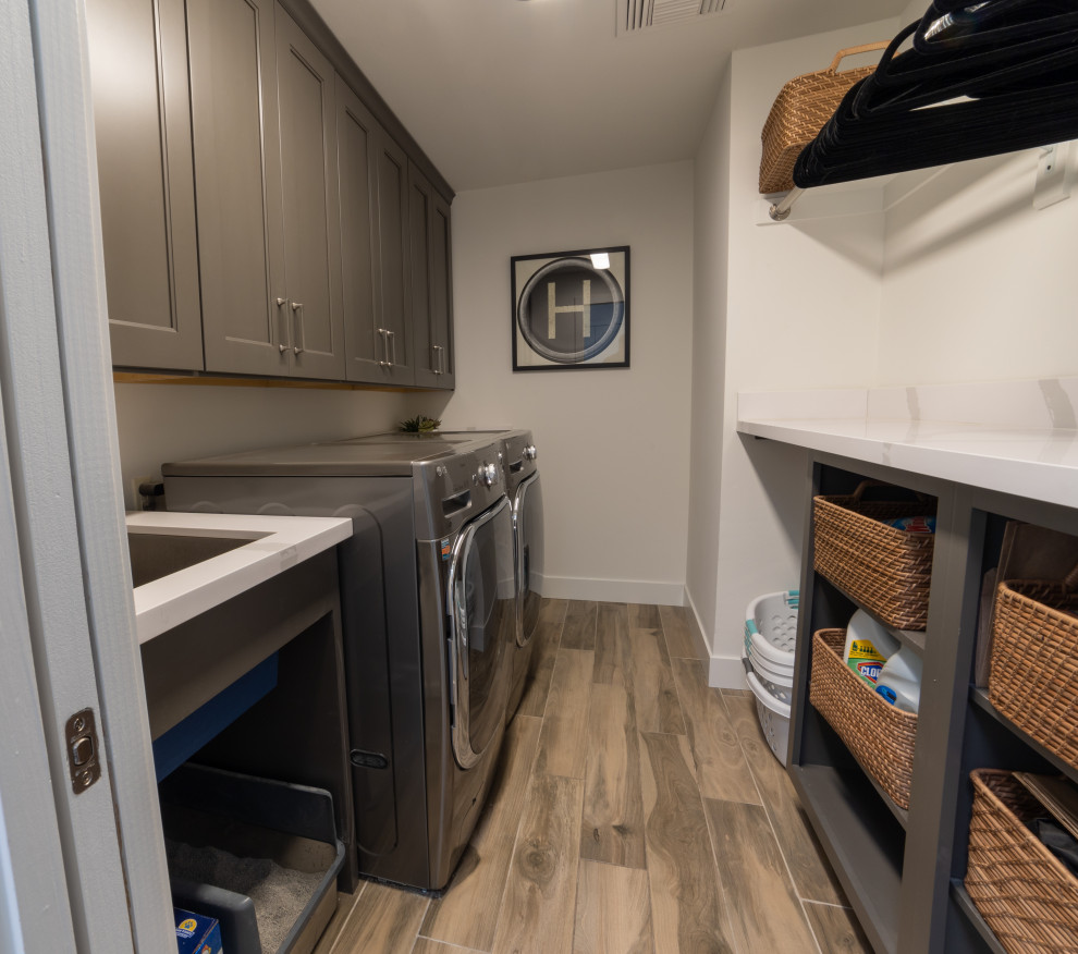 This is an example of a large modern galley utility room in Phoenix with an undermount sink, open cabinets, grey cabinets, quartz benchtops, white walls, a side-by-side washer and dryer and white benchtop.