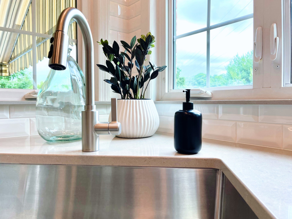 Open concept kitchen - large transitional u-shaped ceramic tile and beige floor open concept kitchen idea with an undermount sink, recessed-panel cabinets, white cabinets, quartz countertops, white backsplash, ceramic backsplash, stainless steel appliances, an island and gray countertops