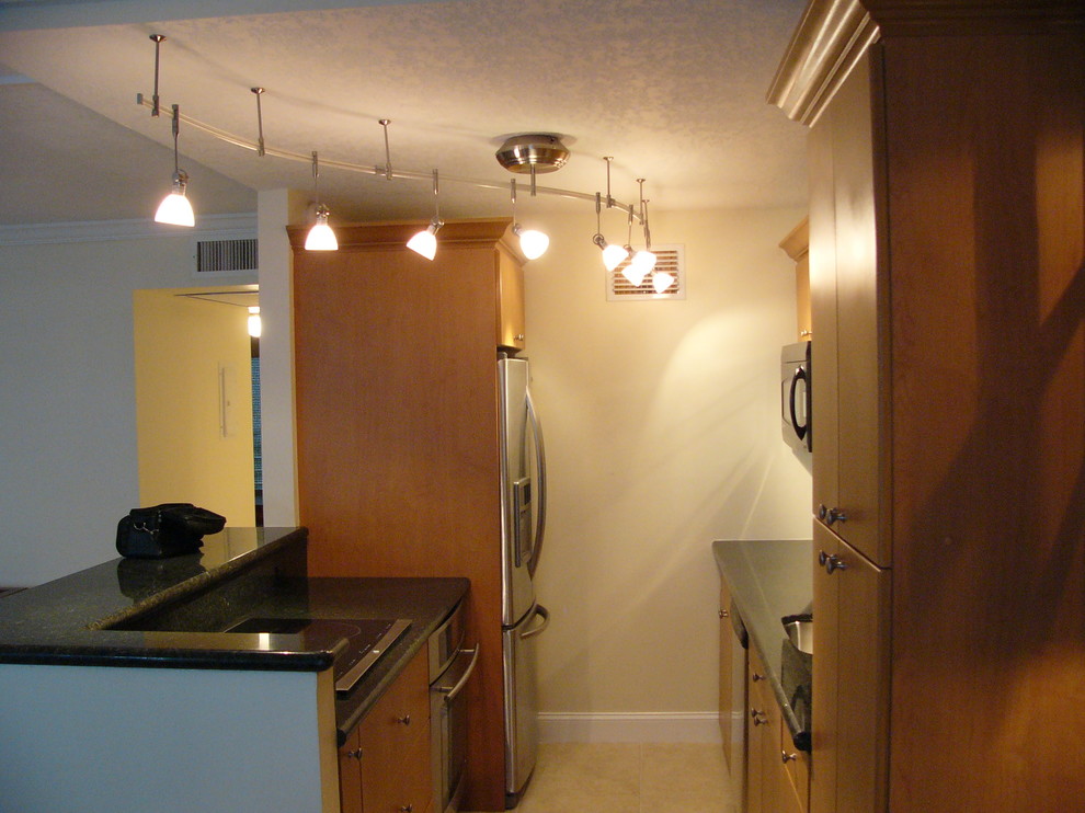Inspiration for a small transitional galley ceramic tile eat-in kitchen remodel in Miami with a single-bowl sink, flat-panel cabinets, medium tone wood cabinets, stainless steel appliances and a peninsula