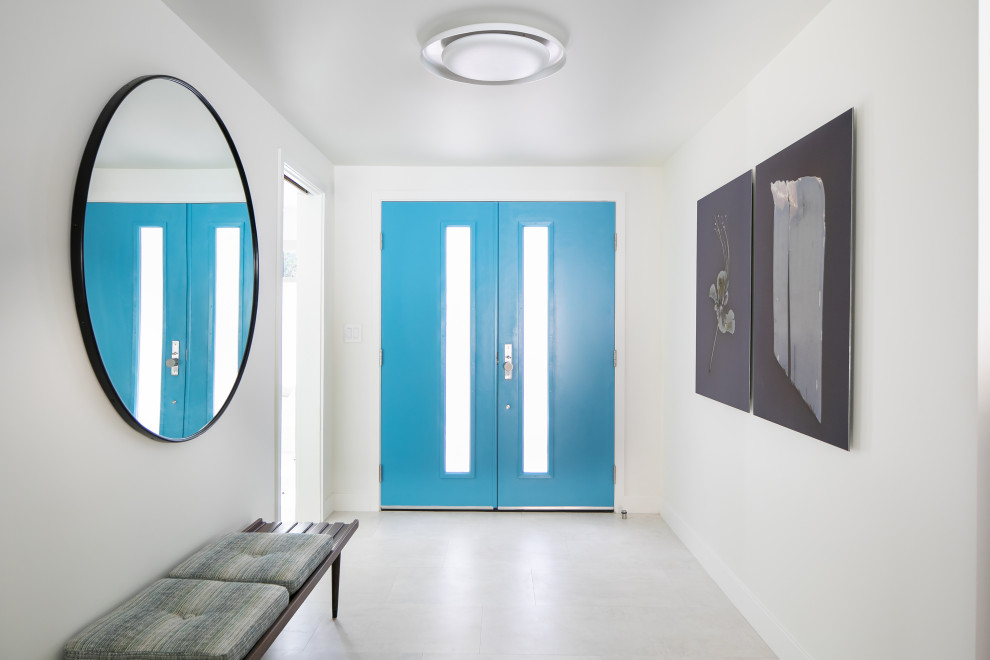 ロサンゼルスにある高級な中くらいなミッドセンチュリースタイルのおしゃれな玄関ロビー (白い壁、磁器タイルの床、青いドア、白い床) の写真