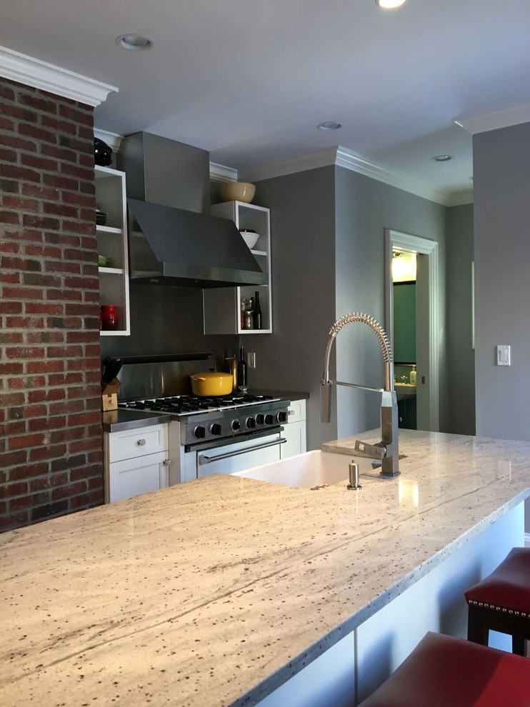 Large transitional l-shaped light wood floor eat-in kitchen photo in Boston with a farmhouse sink, shaker cabinets, white cabinets, marble countertops, gray backsplash, stainless steel appliances and an island