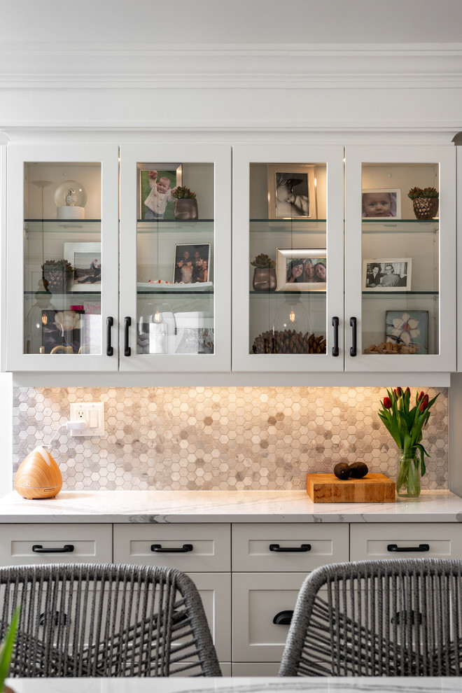 Example of a transitional dark wood floor and brown floor kitchen design with white cabinets, quartz countertops, paneled appliances, an island and white countertops