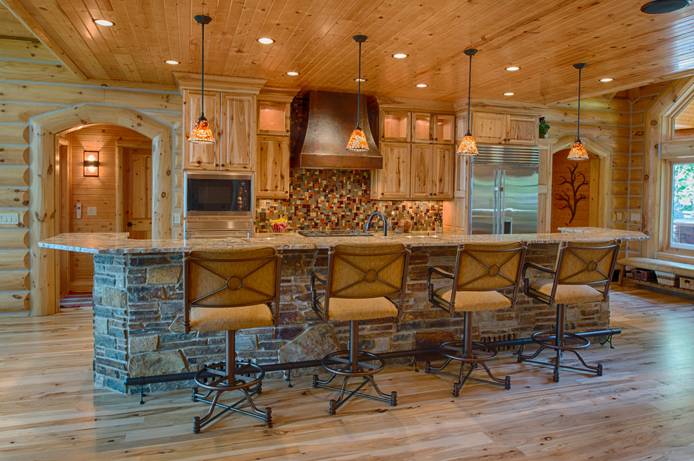 Mountain style kitchen photo with raised-panel cabinets, medium tone wood cabinets, multicolored backsplash and stainless steel appliances