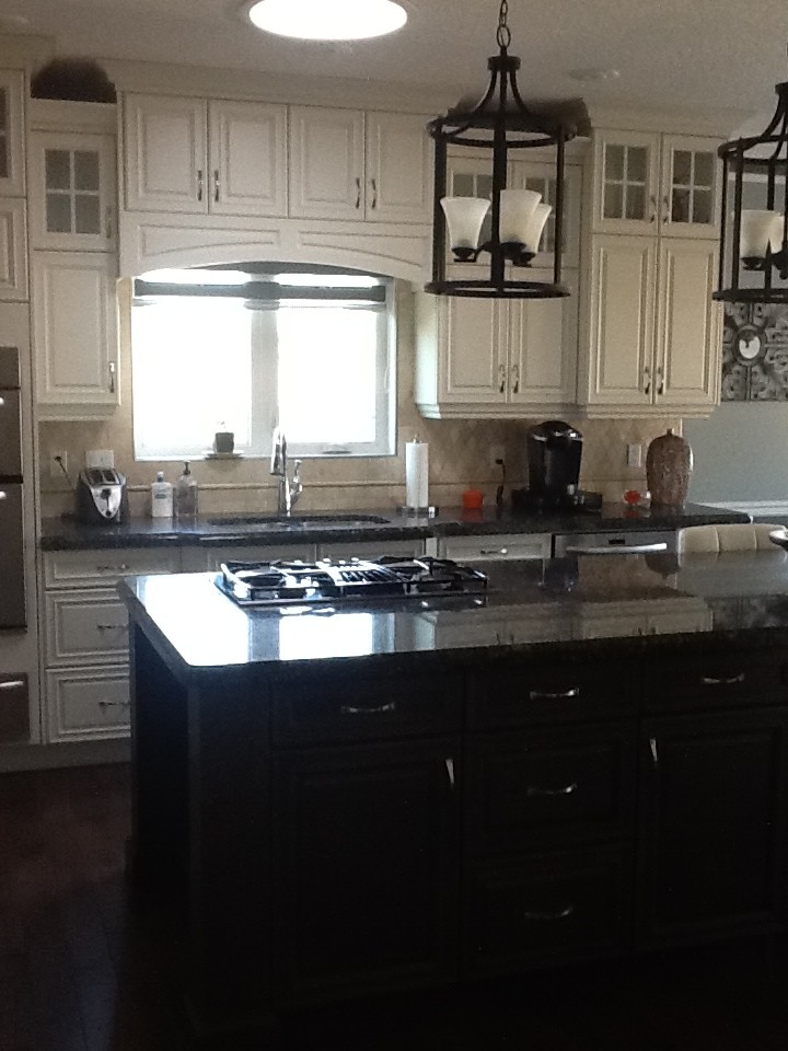 This is an example of a mid-sized country eat-in kitchen in Calgary with stainless steel appliances, with island, a double-bowl sink, raised-panel cabinets, white cabinets, granite benchtops and dark hardwood floors.