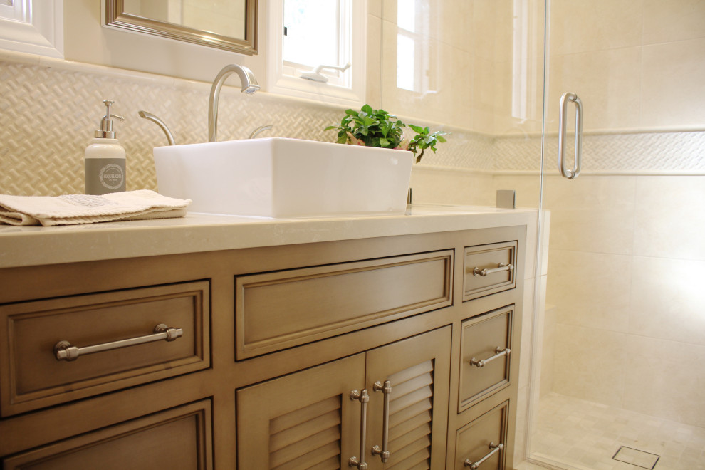 Inspiration for a mid-sized 3/4 bathroom in Los Angeles with raised-panel cabinets, brown cabinets, a one-piece toilet, beige walls, porcelain floors, a vessel sink, quartzite benchtops, beige floor, a hinged shower door and beige benchtops.