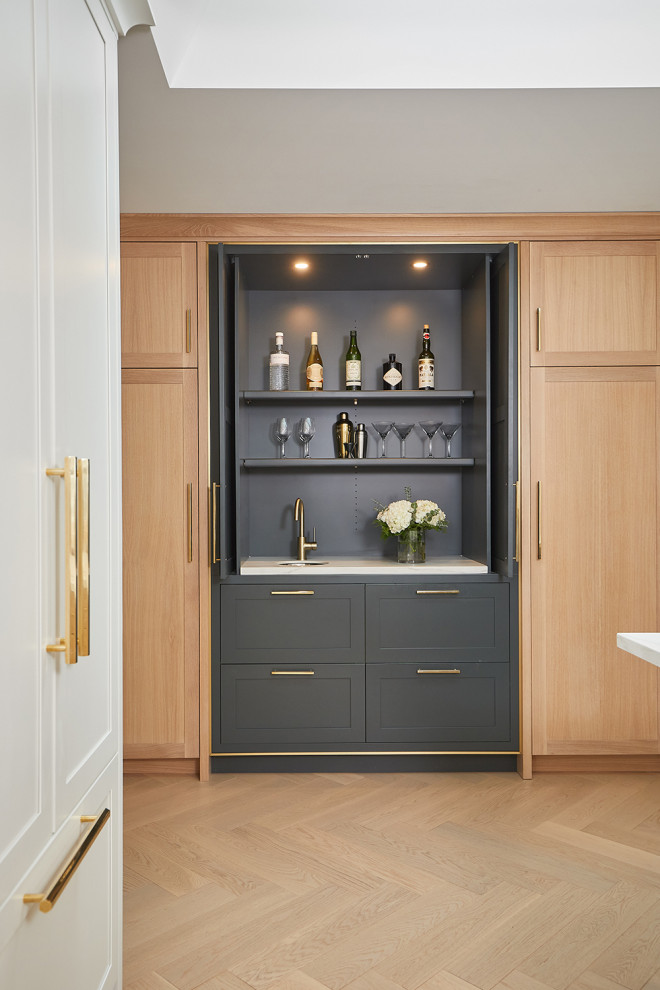 Inspiration for a small contemporary single-wall wet bar in Grand Rapids with an undermount sink, shaker cabinets, green cabinets, quartz benchtops, light hardwood floors and white benchtop.
