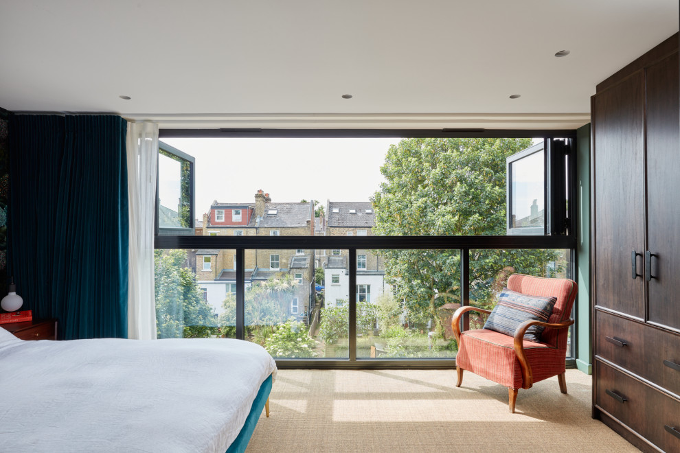 Mittelgroßes Eklektisches Schlafzimmer mit grüner Wandfarbe, Teppichboden, beigem Boden und Tapetenwänden in London