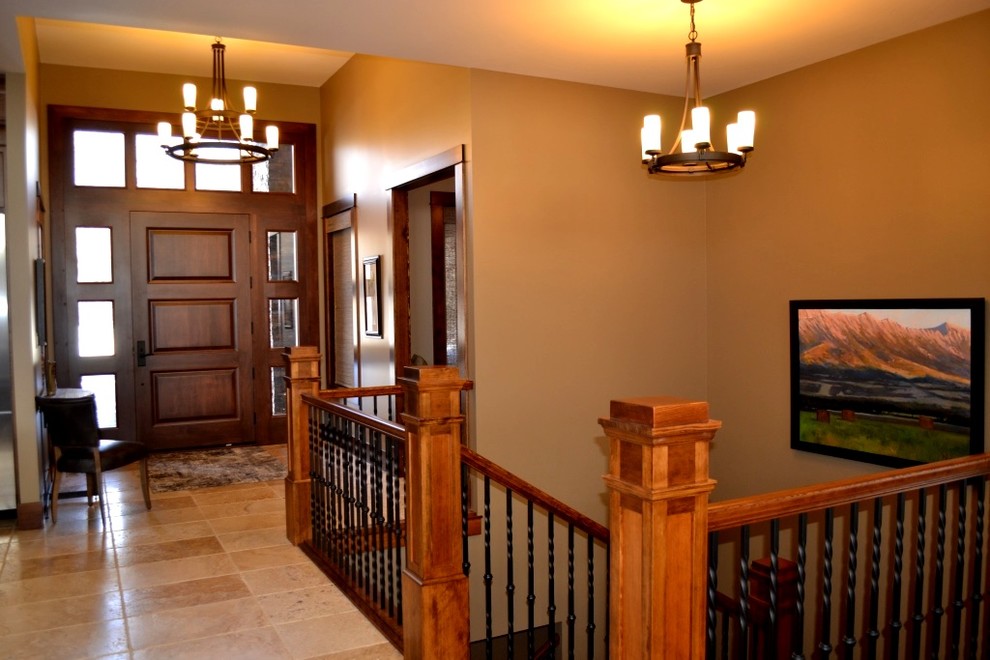 Photo of a mid-sized arts and crafts foyer in Calgary with brown walls, travertine floors, a single front door, a dark wood front door and beige floor.