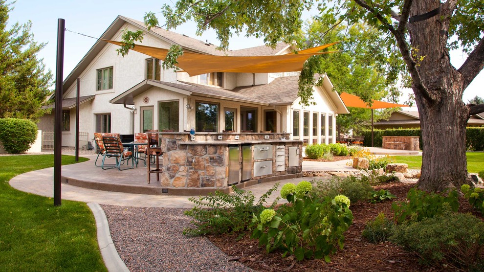 Inspiration for a mid-sized traditional backyard patio in Denver with an outdoor kitchen, natural stone pavers and no cover.