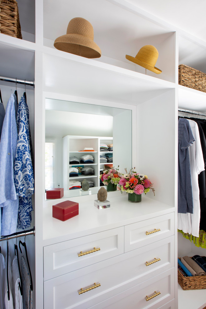 Modelo de armario vestidor de mujer clásico pequeño con armarios con paneles empotrados, puertas de armario blancas, suelo de madera en tonos medios y suelo beige