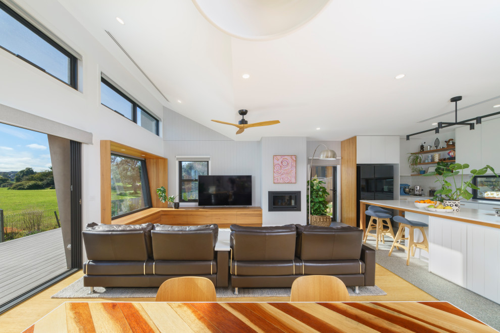 Пример оригинального дизайна: гостиная комната в современном стиле с полом из бамбука и панелями на части стены