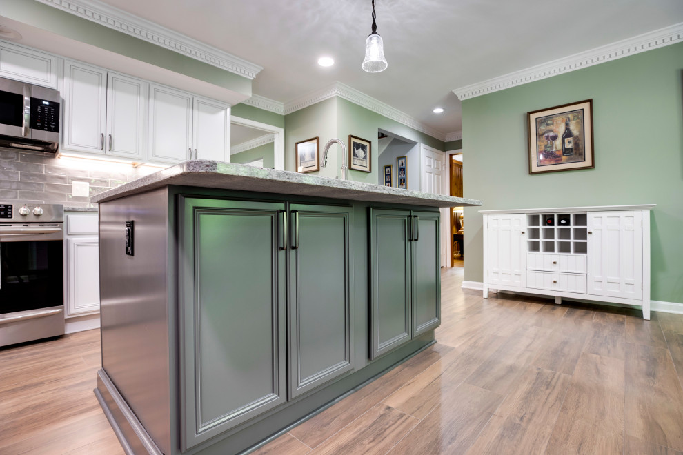 Small traditional u-shaped kitchen in DC Metro with recessed-panel cabinets, engineered stone countertops, stainless steel appliances and an island.