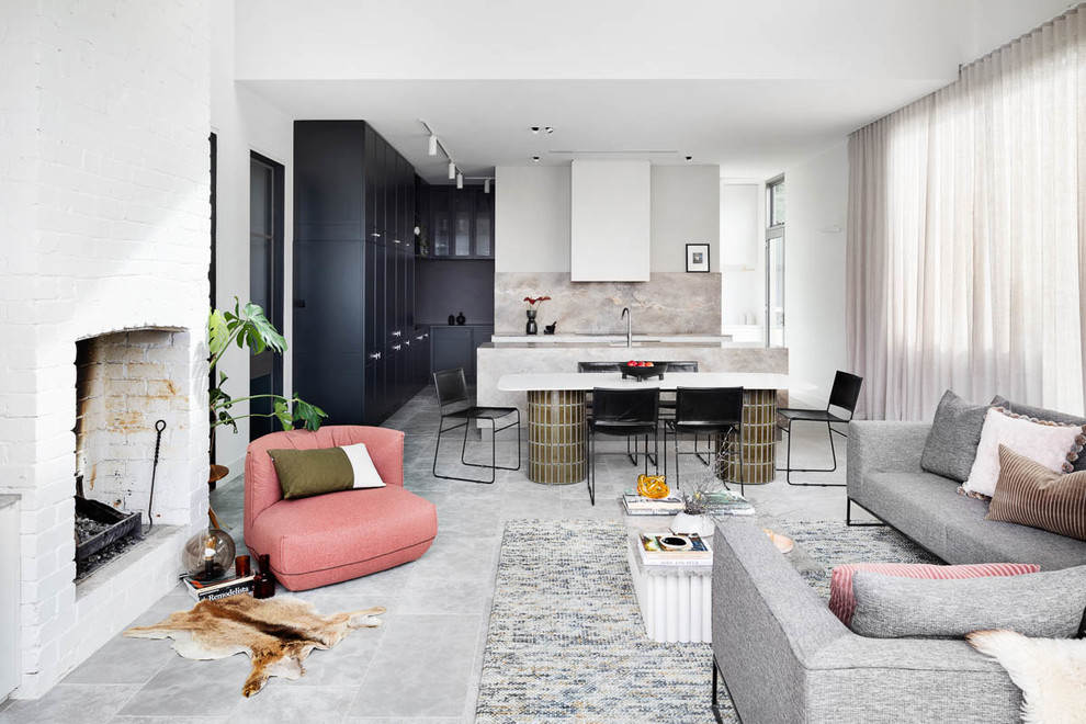 This is an example of a large contemporary open concept family room in Melbourne with a standard fireplace, a brick fireplace surround and grey floor.
