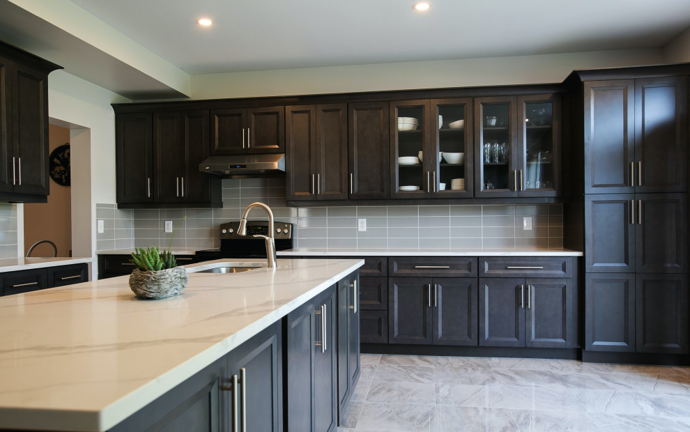 Inredning av ett klassiskt stort flerfärgad flerfärgat kök, med en undermonterad diskho, luckor med infälld panel, skåp i mörkt trä, bänkskiva i kvartsit, grått stänkskydd, stänkskydd i keramik, rostfria vitvaror, klinkergolv i porslin, en köksö och flerfärgat golv