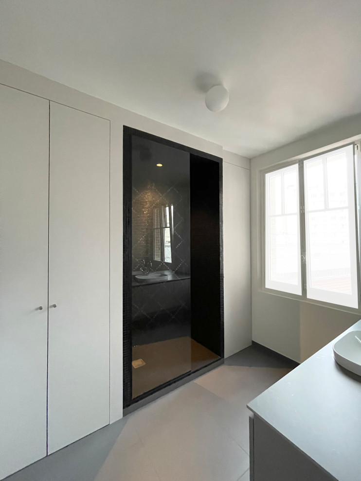 Inspiration for a mid-sized contemporary 3/4 bathroom in Paris with beaded inset cabinets, grey cabinets, a curbless shower, grey walls, ceramic floors, a drop-in sink, granite benchtops, black floor, a laundry, a single vanity, a built-in vanity and wood walls.