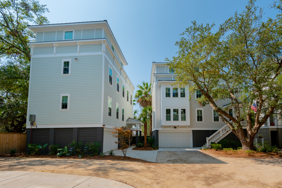 Photo of a mid-sized tropical three-storey green house exterior in Charleston with wood siding and a metal roof.