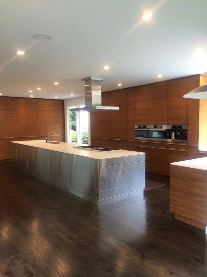 Design ideas for a large modern u-shaped open plan kitchen in San Francisco with an undermount sink, flat-panel cabinets, light wood cabinets, quartz benchtops, panelled appliances, dark hardwood floors, with island, brown floor and white benchtop.