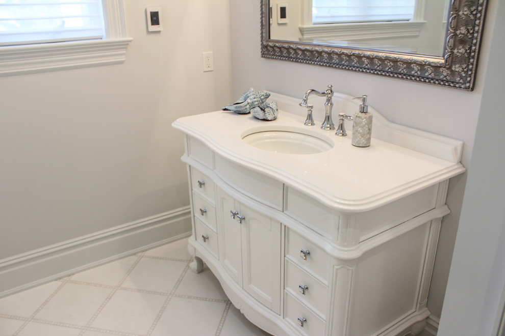 This is an example of a large traditional 3/4 bathroom in New York with beaded inset cabinets, dark wood cabinets, a one-piece toilet, beige tile, ceramic tile, beige walls, ceramic floors, a drop-in sink and marble benchtops.